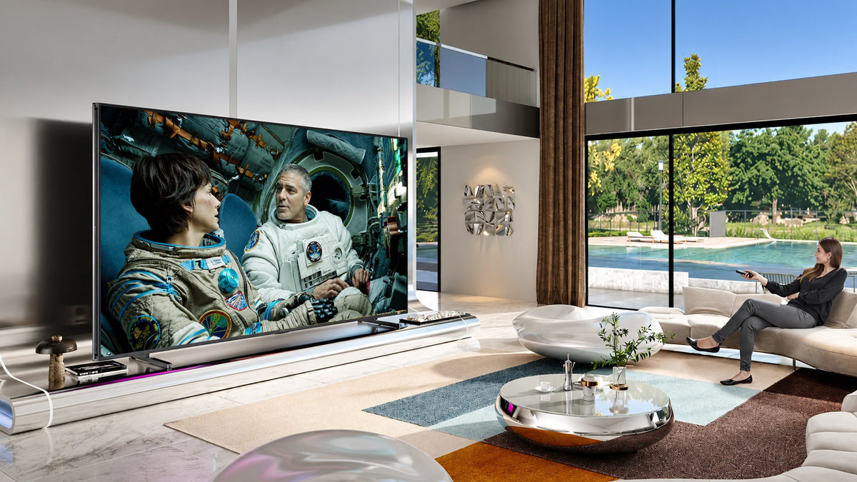 A massive 98 inch smart TV setup inside bright luxury open living room area.